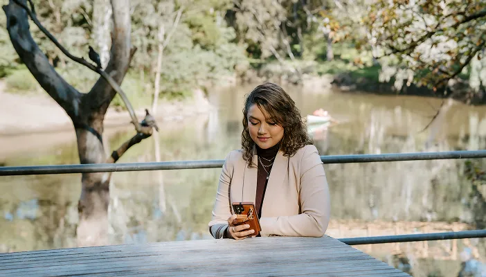 A woman checking her phone at an outdoor table